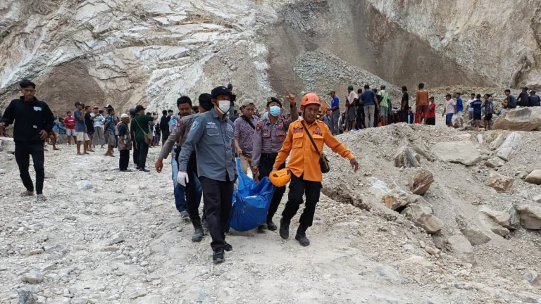BNPB operatives carrying a victim after a rock collapse in indonesia